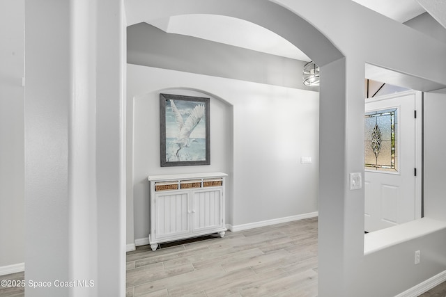 hall featuring baseboards and light wood finished floors