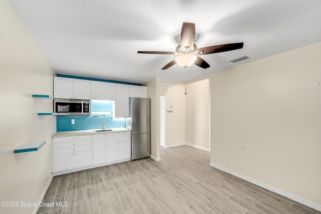 kitchen featuring a sink, light wood-style floors, visible vents, and stainless steel appliances