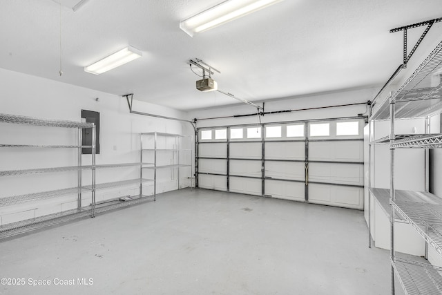 garage featuring electric panel and a garage door opener