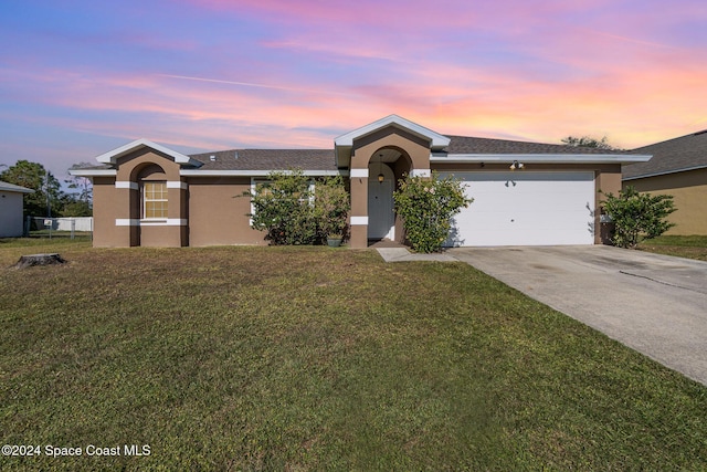 single story home with a front yard, an attached garage, driveway, and stucco siding