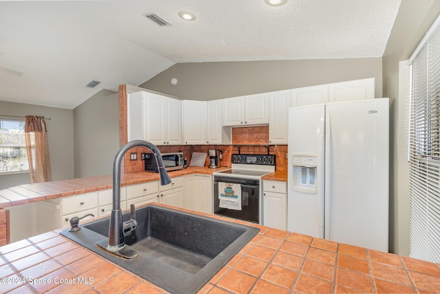 kitchen with stainless steel microwave, visible vents, white fridge with ice dispenser, electric range, and a sink