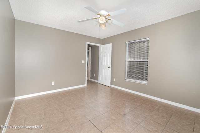 unfurnished room featuring baseboards, a textured ceiling, and a ceiling fan