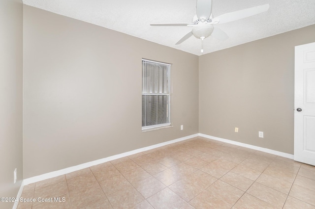 unfurnished room featuring light tile patterned floors, a textured ceiling, baseboards, and a ceiling fan