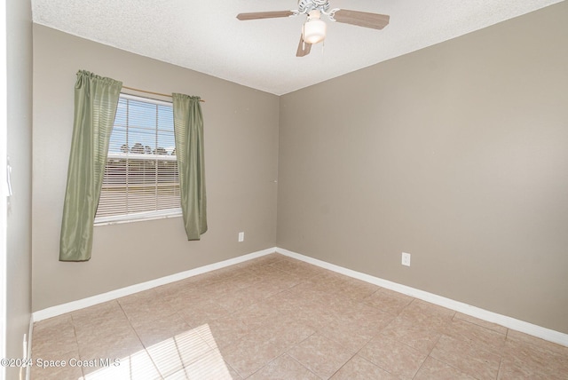 empty room featuring ceiling fan, a textured ceiling, and baseboards