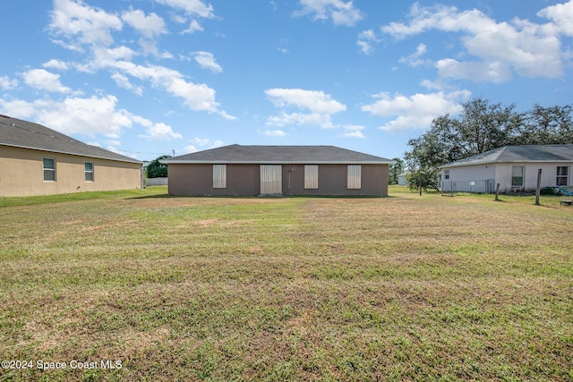 rear view of house featuring a lawn