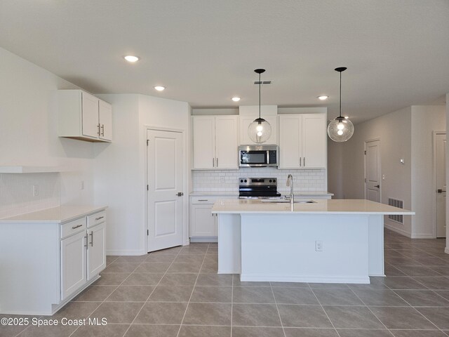 kitchen with visible vents, appliances with stainless steel finishes, an island with sink, and a sink