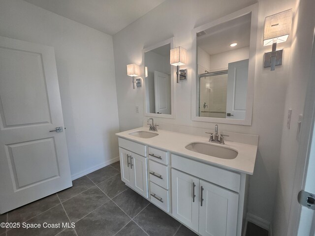 bathroom featuring double vanity, tile patterned flooring, a shower stall, and a sink