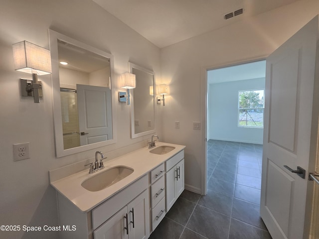 bathroom featuring a sink, visible vents, double vanity, and tile patterned flooring