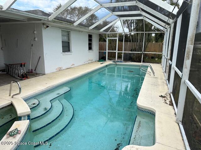 view of swimming pool with a lanai, a fenced in pool, a patio, and fence