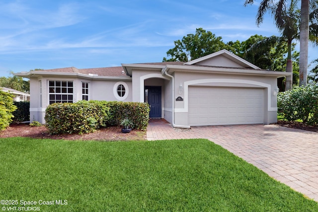 single story home with a front lawn, a garage, driveway, and stucco siding