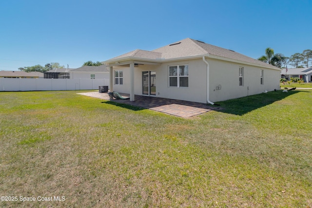 rear view of house featuring fence, central AC, stucco siding, a patio area, and a lawn