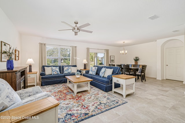 living room with visible vents, ceiling fan with notable chandelier, and baseboards