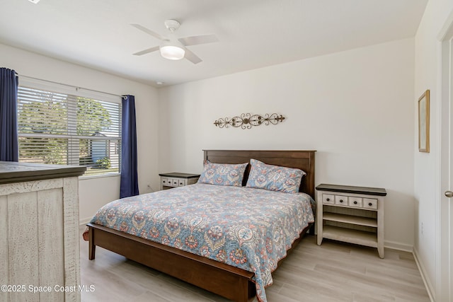 bedroom featuring light wood finished floors, a ceiling fan, and baseboards