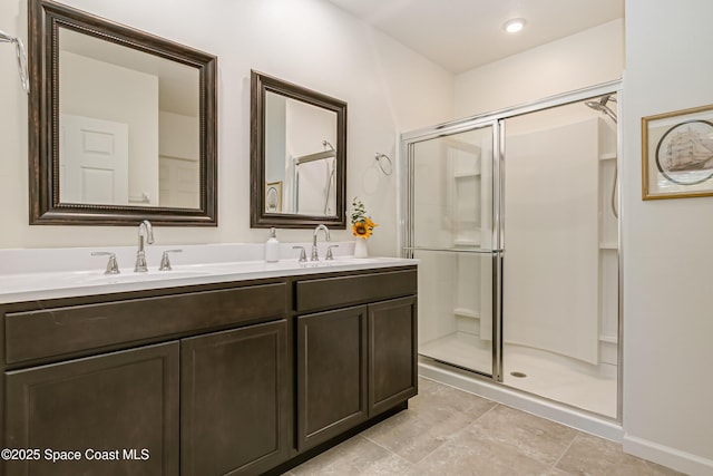 full bath with double vanity, a stall shower, and a sink