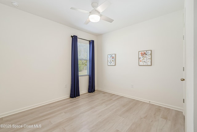 spare room with baseboards, light wood-type flooring, and ceiling fan