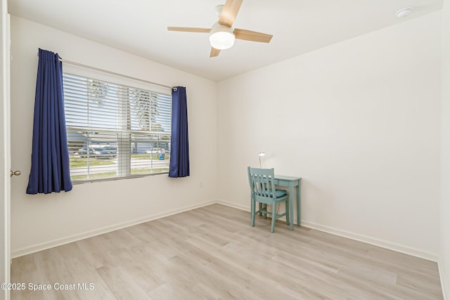 empty room featuring wood finished floors, baseboards, and ceiling fan