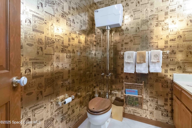 bathroom featuring vanity, tile patterned floors, toilet, and tiled shower