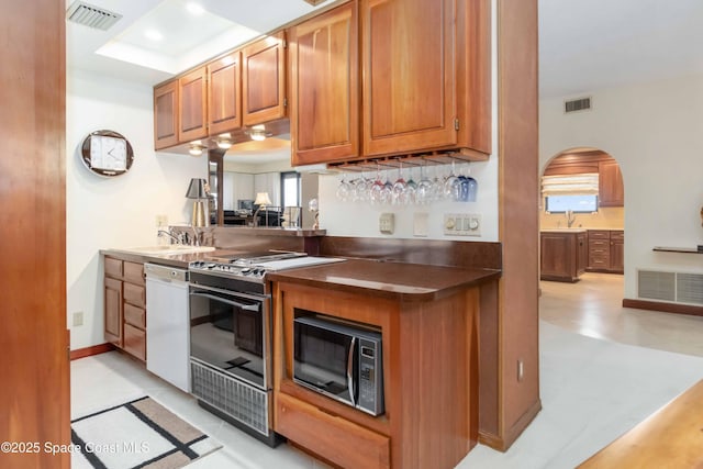 kitchen with dishwasher, gas stove, visible vents, and a sink