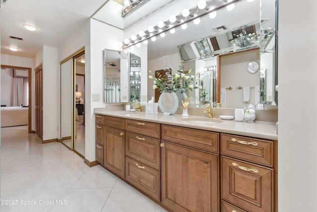 ensuite bathroom featuring tile patterned flooring, visible vents, ensuite bath, and a sink