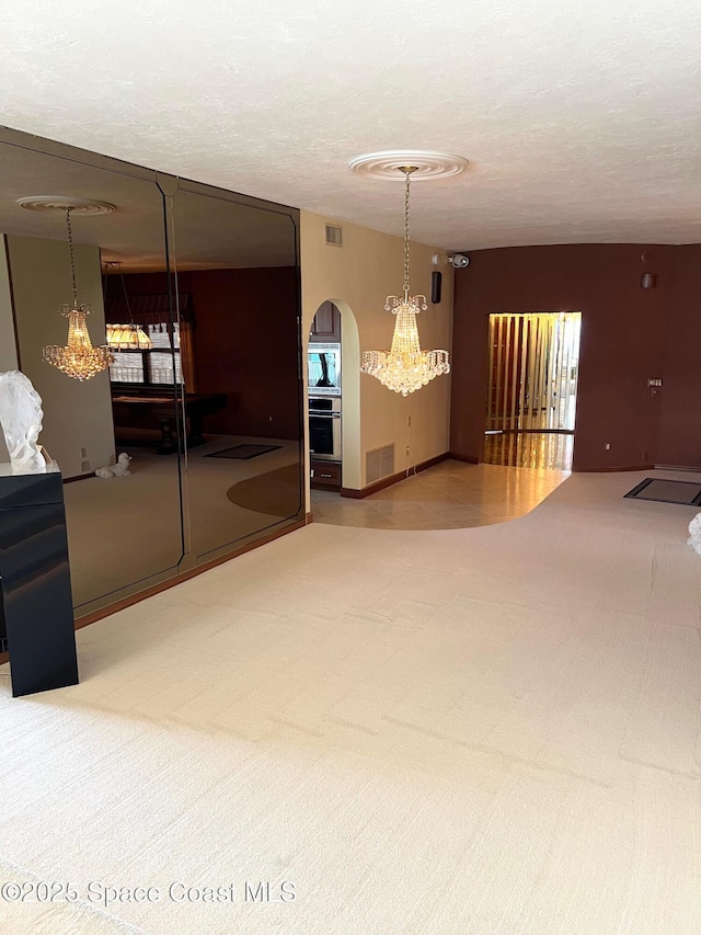 750 N Atlantic Ave Ph 4, Cocoa Beach, FL 32931 - empty room with carpet, arched walkways, and a textured ceiling