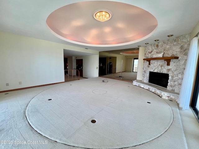 750 N Atlantic Ave Ph 4, Cocoa Beach, FL 32931 - unfurnished living room featuring carpet floors, a fireplace, and a raised ceiling