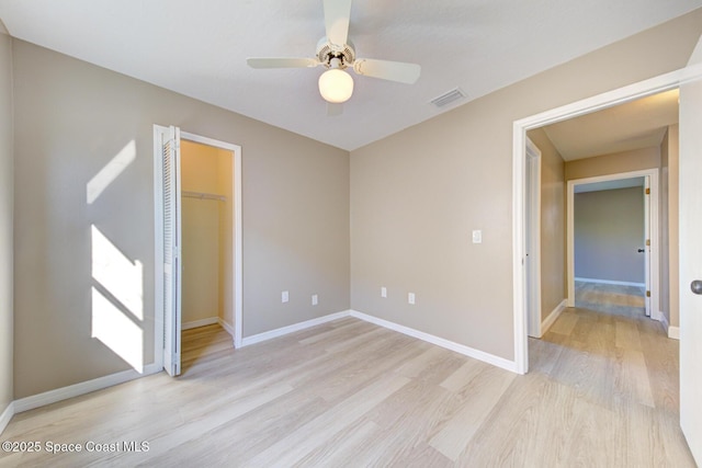 unfurnished bedroom with light wood-style floors, visible vents, a closet, and baseboards