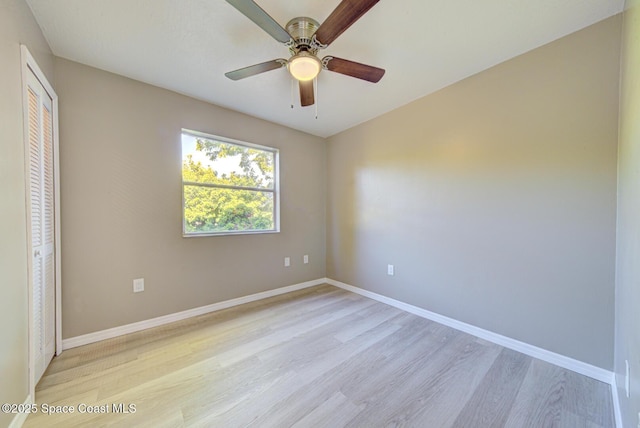 empty room featuring baseboards, light wood-style flooring, and a ceiling fan