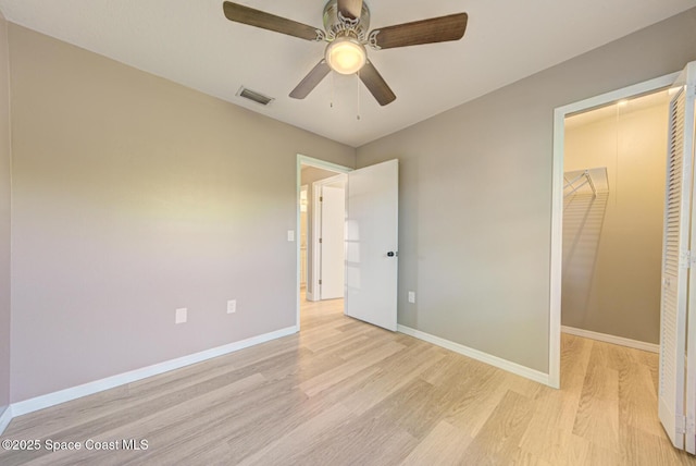 unfurnished bedroom featuring visible vents, baseboards, ceiling fan, light wood-style flooring, and a closet