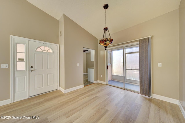 entrance foyer with high vaulted ceiling, light wood-type flooring, and baseboards