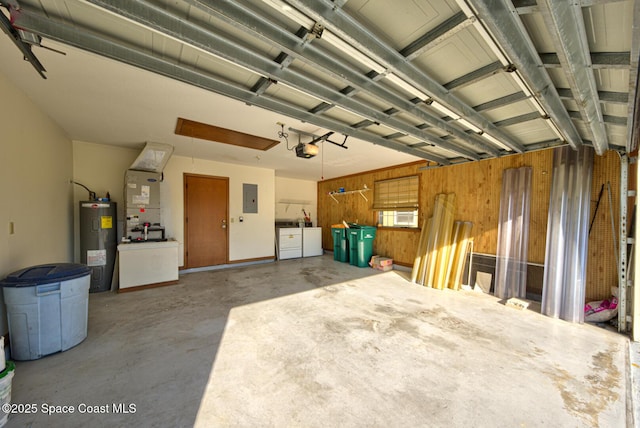 garage featuring heating unit, electric panel, separate washer and dryer, electric water heater, and a garage door opener