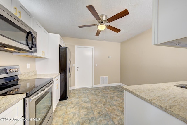 kitchen featuring visible vents, ceiling fan, stainless steel appliances, white cabinets, and a textured ceiling