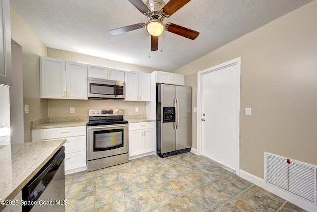 kitchen featuring visible vents, a ceiling fan, appliances with stainless steel finishes, white cabinets, and light stone countertops