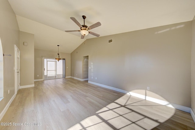 spare room with visible vents, light wood finished floors, baseboards, lofted ceiling, and ceiling fan with notable chandelier