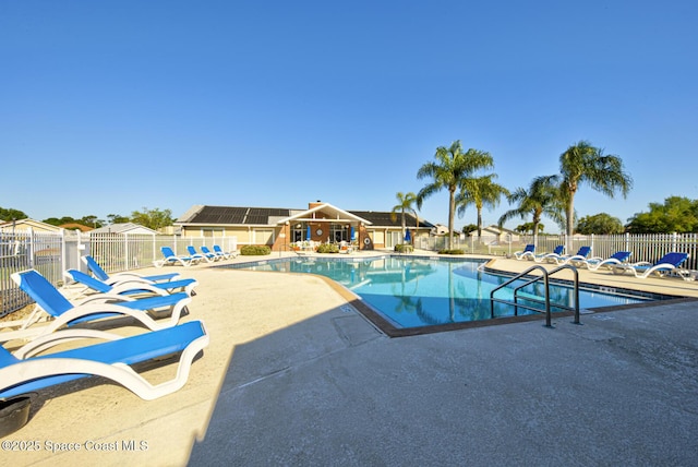 pool with a patio and fence