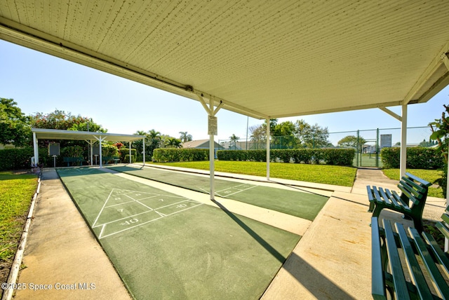 view of property's community featuring shuffleboard, a yard, fence, and a gate