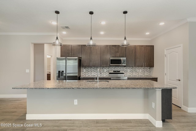 kitchen featuring a sink, stainless steel appliances, dark brown cabinetry, and backsplash