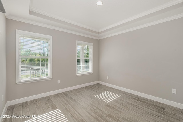 unfurnished room featuring baseboards, crown molding, and light wood-style floors