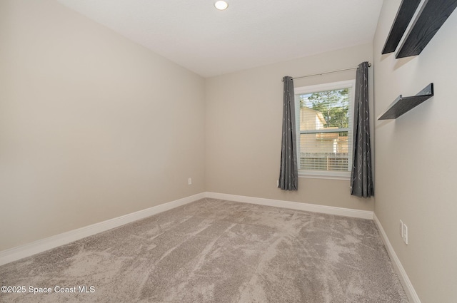 spare room featuring baseboards and carpet floors