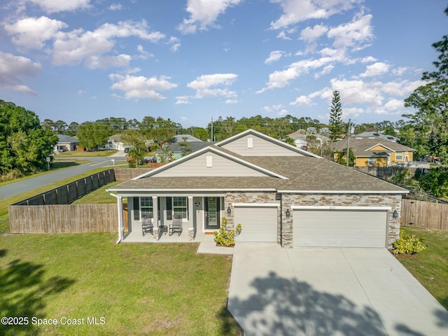 view of front of home with a front yard, fence, roof with shingles, concrete driveway, and a garage