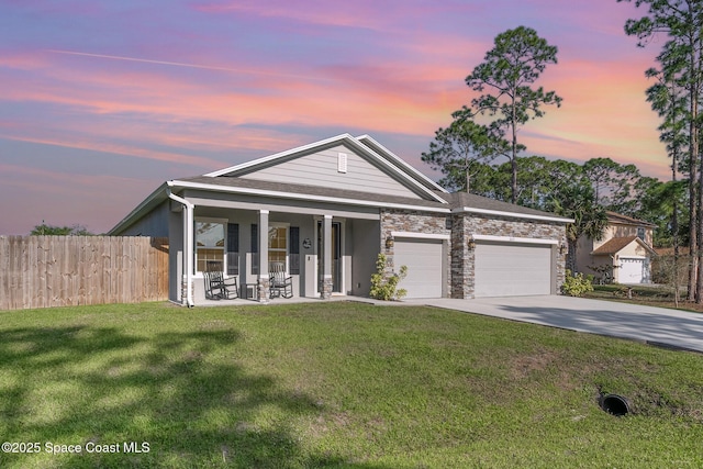 view of front facade featuring fence, a porch, concrete driveway, a lawn, and an attached garage