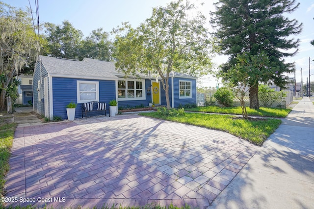 single story home featuring roof with shingles