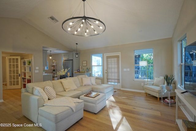 living area with light wood finished floors, visible vents, plenty of natural light, and vaulted ceiling