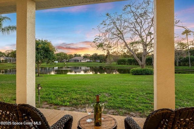 yard at dusk featuring a water view