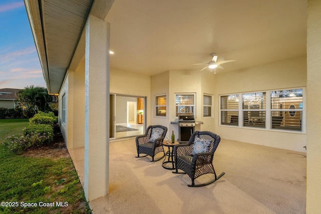 patio terrace at dusk with grilling area and ceiling fan