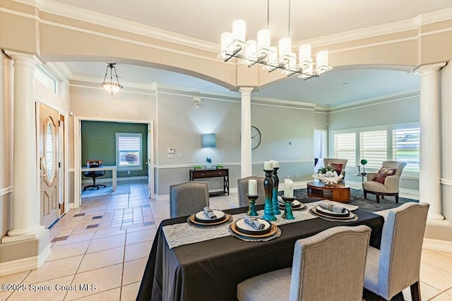 dining space with light tile patterned floors, decorative columns, arched walkways, and ornamental molding