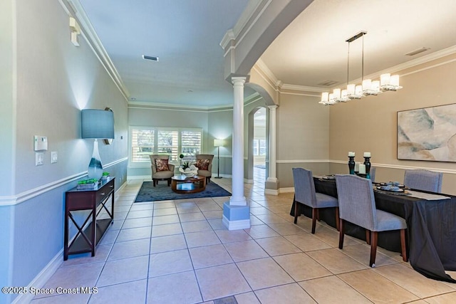 tiled dining space featuring arched walkways, visible vents, crown molding, and ornate columns