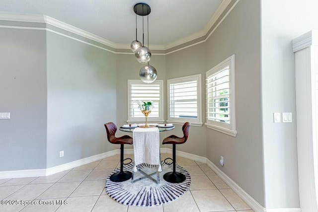 dining room with crown molding, light tile patterned flooring, a healthy amount of sunlight, and baseboards