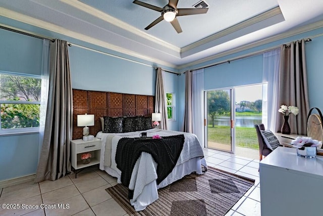 bedroom featuring multiple windows, ornamental molding, a tray ceiling, and access to outside