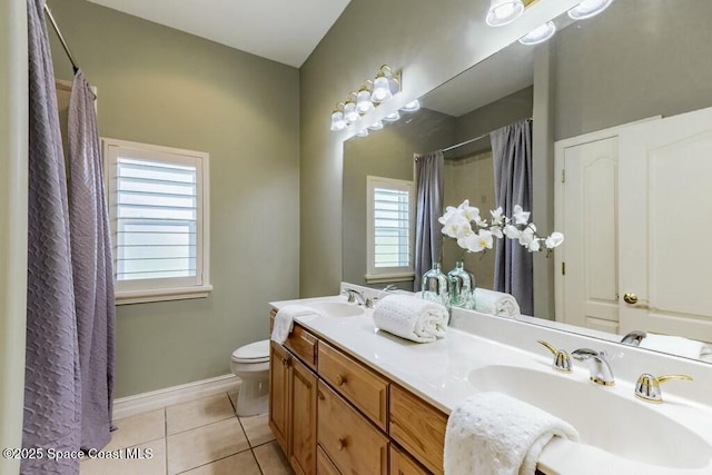 bathroom featuring tile patterned floors, toilet, a sink, a shower with shower curtain, and baseboards