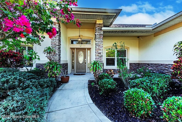 entrance to property with stone siding and stucco siding